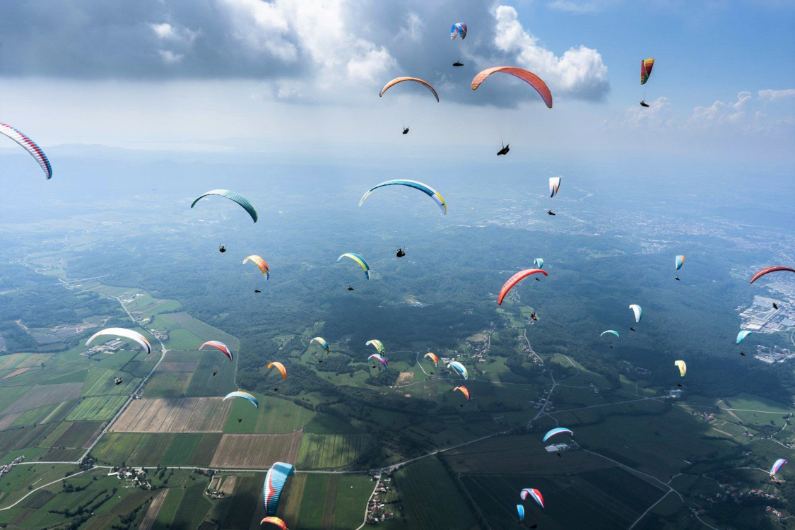 Groep paragliders boven landschap